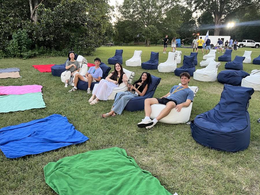 Bean bag chairs facing an outdoor movie screen on a lawn